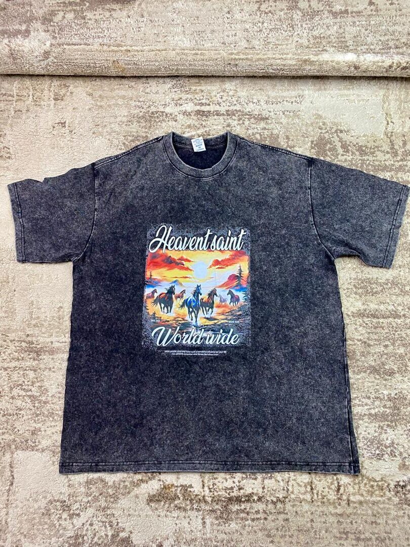 Vintage-wash black streetwear t-shirt featuring a scenic graphic of wild horses running under a bright orange sunset with 'Heavent Saint Worldwide' text, custom DTF printed by Whavieprints.