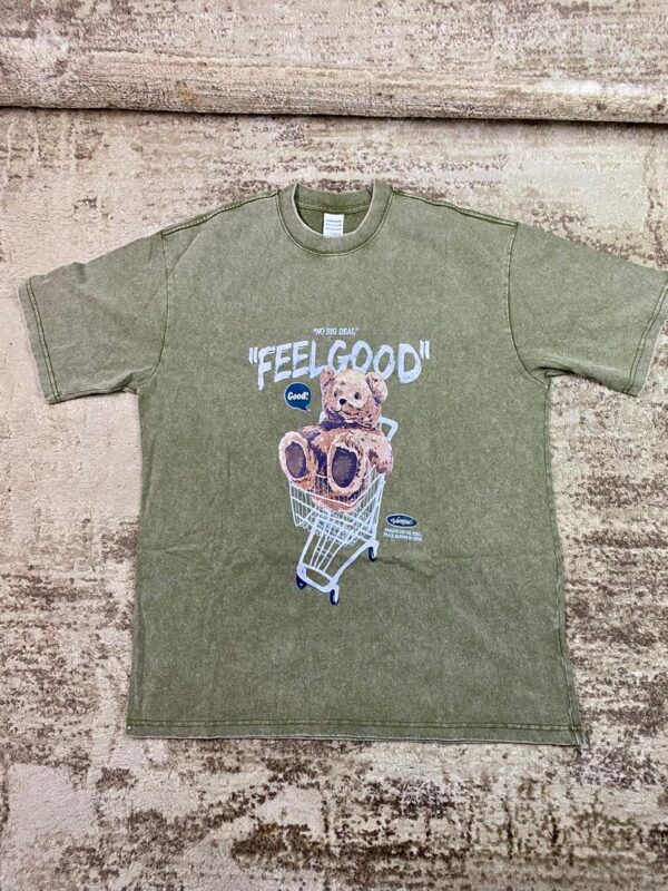 Vintage-wash olive green streetwear t-shirt featuring a graphic of a brown teddy bear in a shopping cart under 'Feel Good' text, custom DTF printed by Whavieprints.