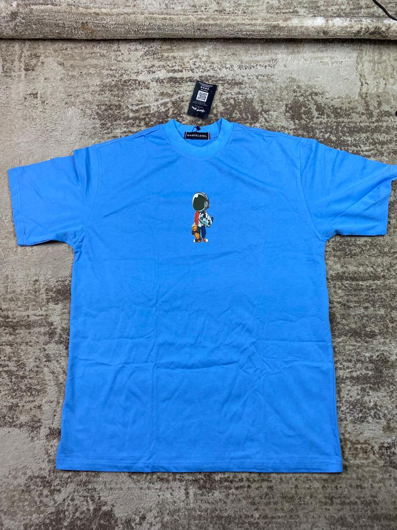 Sky blue streetwear t-shirt with a small central graphic illustration of a cartoon astronaut wearing a spacesuit, custom DTF printed by Whavieprints.